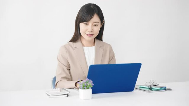 ノートパソコンを使う若い女性　ビジネスイメージ