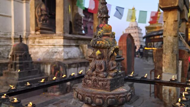 Small religious shine or statue of Buddha surrounded by candles at the Swayambhunath Temple in Kathmandu, Nepal