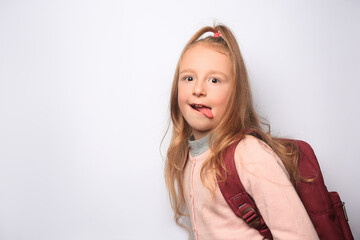 Obraz premium Emotional little girl with backpack on white background. Space for text