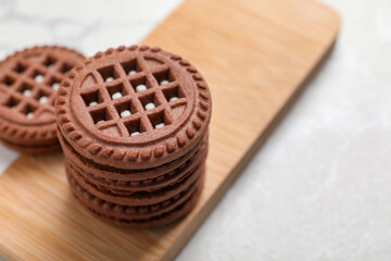 Tasty chocolate sandwich cookies with cream on light table, space for text