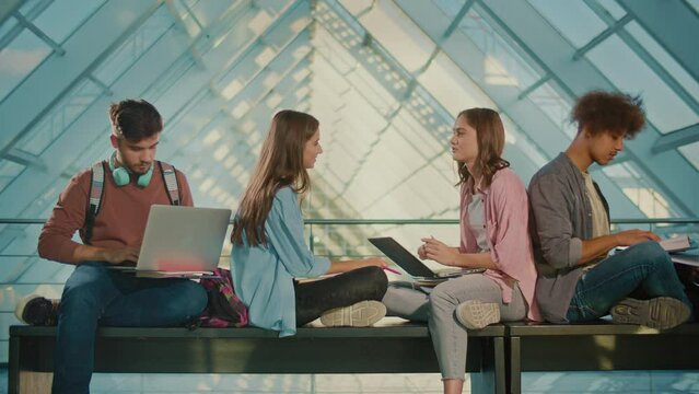 Group of Students, High School Pupils Gather in University Hallway, Discuss Topics, Work Together on Creative Tasks, and Prepare for University Tests or Exams Using a Laptop. Education, Modern Tech