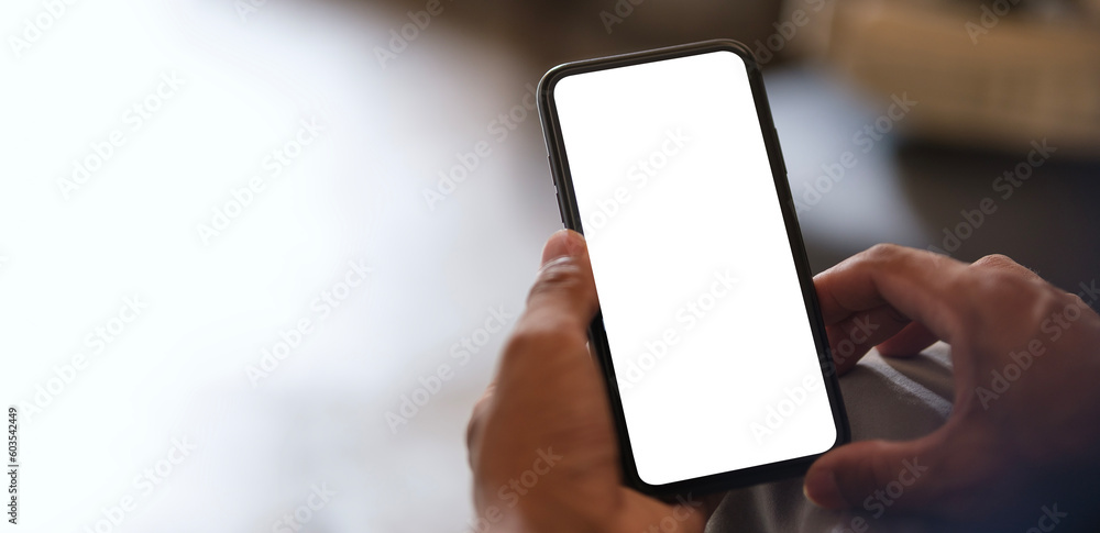 Poster closeup view of hands holding smartphone with blank screen and left side with empty space for your a