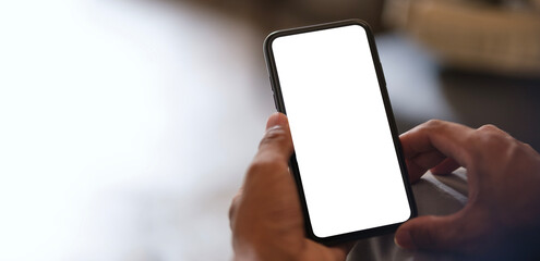 Closeup view of hands holding smartphone with blank screen and left side with empty space for your advertise or text message.