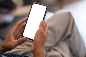Cropped shot of man holding smartphone with mockup white blank display, empty screen for app ads.