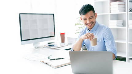 Young business man working at home office with laptop and papers on desk