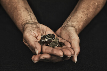 Hände mit Geldmünzen als Symbol für Armut