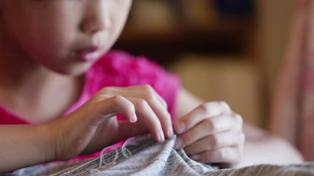  家で裁縫している小学生の女の子の様子