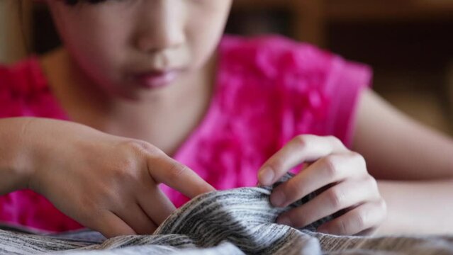  家で裁縫している小学生の女の子の様子