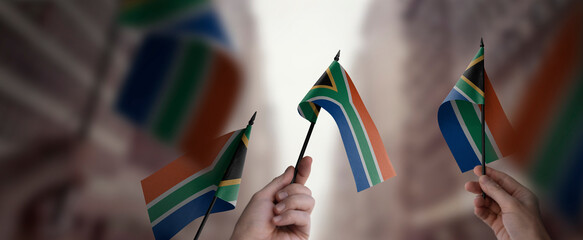 A group of people holding small flags of the South Africa in their hands