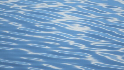 The glossy light blue river water texture with patterns closeup