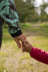 ittle daughter with her mother in the day in a park, lifestyle of family taking a walk, care and protection of the child, wallpaper