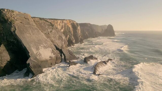 Aerial establishing shot of the large cliffs along the coast of Praia da Adraga