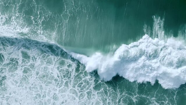 Slow motion shot of a wave building up and breaking at Nazare beach