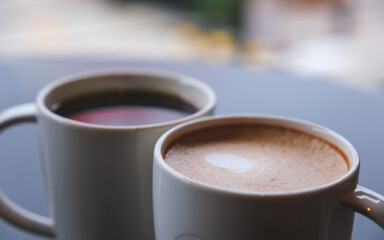 Closeup image of two cups of hot coffee with blurred background