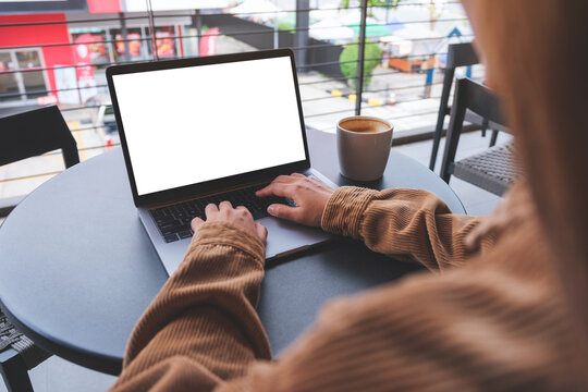 Mockup image of a woman using and typing on laptop computer with blank white desktop screen