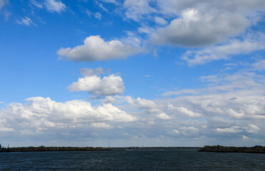 Obraz premium On a sunny day, a panoramic view of the beautiful seascape and the blue sky with white clouds.