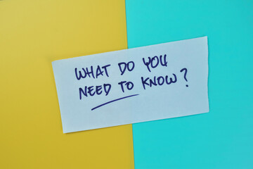 Concept of What Do You Need To Know? write on sticky notes isolated on Wooden Table.