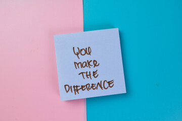 Concept of You Make The Difference write on sticky notes isolated on Wooden Table.