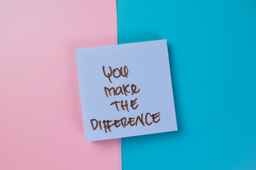 Concept of You Make The Difference write on sticky notes isolated on Wooden Table.