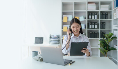 Consultant, Asian businesswoman working on the phone who discussion financial work and marketing business plan to increase company profits, ready to use computer and marketing planning documents.