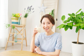 Obraz na płótnie Canvas 自宅で豆乳を飲む女性　カメラ目線