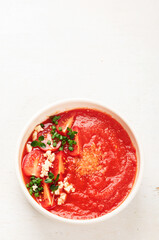 Tomato soup on white table, top view