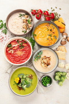 Composition with various soups, ingredients and space for text on white background. Healthy food.