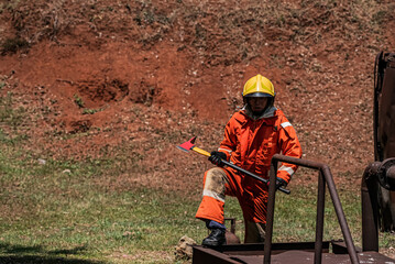 Naklejka premium In the midst of a rusty and worn environment a firefighter stands tall holding an ax with a resolute and determined expression ready for any challenge that may come their way.