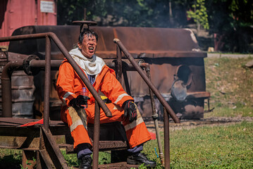 Firefighters sitting outdoors refreshed after quenching the heat with water in his hand.