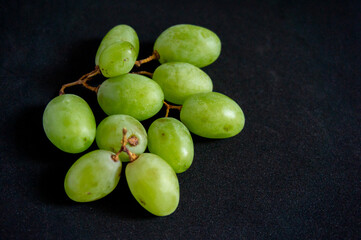 Fresh green grapes picked from the tree on a black background