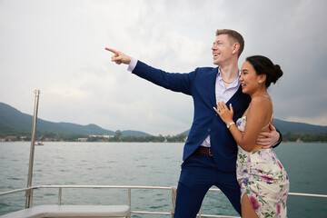 young couple looking to something on luxury yacht