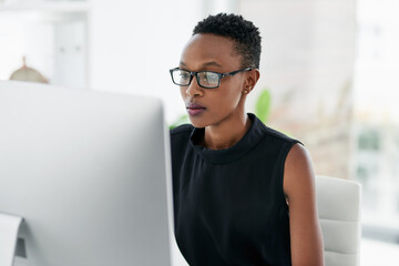 Business, computer and serious black woman in office for research, planning or concentration....