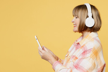 Side view elderly blonde caucasian woman 50s years old she wear casual clothes headphones listen to...