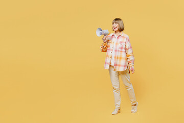 Full body elderly surprised shocked blonde woman 50s years old wear casual clothes hold in hand megaphone scream announces discounts sale Hurry up isolated on plain yellow background studio portrait.