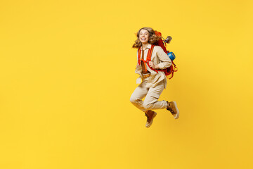 Fototapeta na wymiar Full body sideways smiling young woman carry bag with stuff mat jump high isolated on plain yellow background. Tourist leads active lifestyle walk on spare time. Hiking trek rest travel trip concept.
