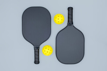Pickleball paddles and balls on grey