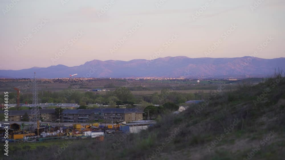 Wall mural plane taking off at sunrise with mountains in the background lit by the sun