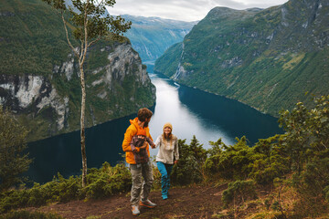 Family traveling in Norway together hiking above Geiranger fjord Father and mother with infant baby...
