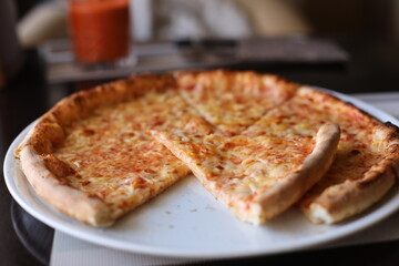 Beautiful pizza on a table. Tasty pizza in a frying pan. Delicious pizza on a wooden board.