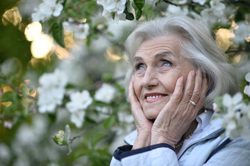 Portrait of happy senior woman smiling in autumn park