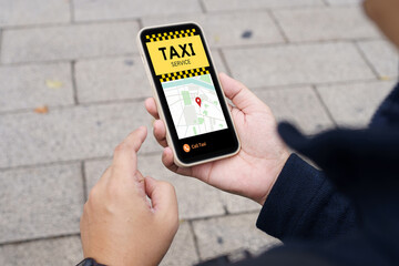 Man in downtown city street ordering taxi using smart phone app Booking taxi using application...