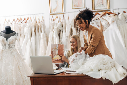 Workers in a bridal salon talk to a costumer over video call.