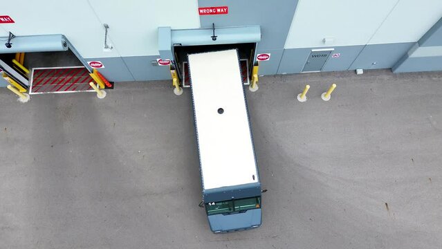 Amazon Vans pull out of Amazon warehouse, aerial drone, straight down