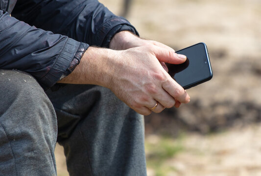 Man using smart phone in the park. Close-up image