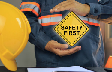 Engineers or supervisors holding a safety first sign to remind operators to strictly follow safety measures to prevent work accidents and increase efficiency. ISO 45001.