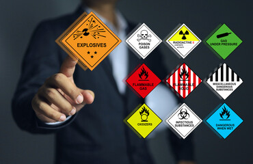 Supervisor or leader pointing to the explosives symbols and all type of the various types of dangerous goods involved.