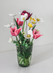 A bouquet of spring garden flowers on a light background, copy space