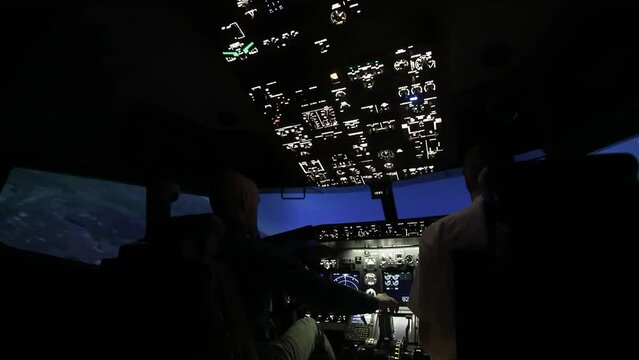 Two pilots in the cockpit during training to fly the aircraft. Back view. Airplane flight simulation. Airplane flight concept.