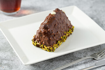 Dessert Cake from Malaga on stone table. Cake with banana inside, covered with chocolate sauce and hazelnuts