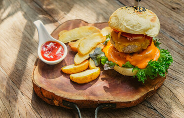 Burgers and potato chips complemented with ketchup on a wooden tray, American-style, elegant and appetizing in a vintage-style restaurant.